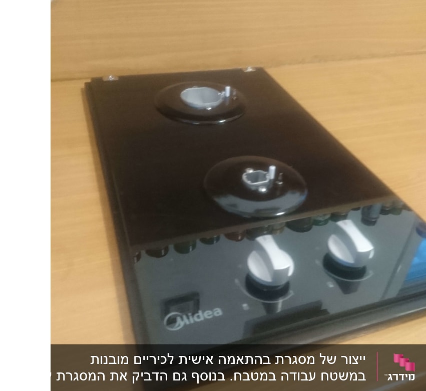 כיריים שחורות עם כפתורים לבנים על שולחן עץ